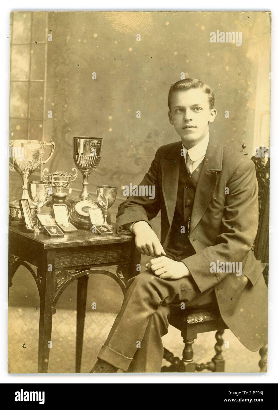 Original Studio-Porträtfoto eines gut aussehenden, selbstbewussten Teenagers an der King Edward V1 Five Ways Grammar School (K.E. G.S.) mit Preisen - es gibt einen großen silbernen Pokal aus dem Jahr 1911 und viele andere Medaillen und Pokale. Bartley Green, Birmingham, West Midlands, England, Großbritannien um 1914 Stockfoto