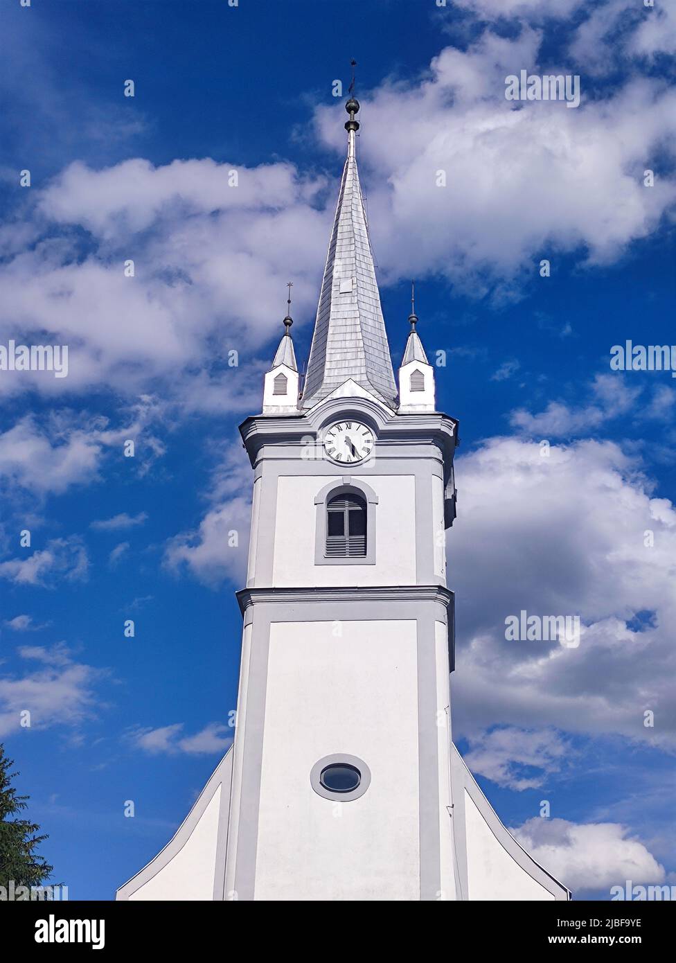 Katholische Kirche und tiefblauer Himmel, Architektur in der Ukraine. Christlicher Tempel mit Uhr Stockfoto