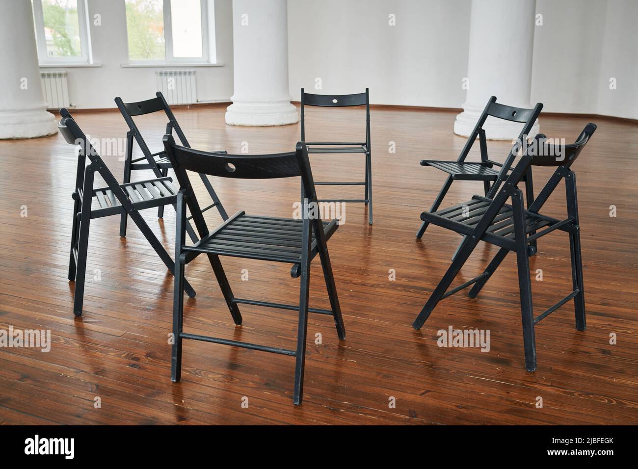 Ein Teil des Hörsaals oder ein geräumiges Auditorium mit einer Gruppe von Stühlen, die einen Kreis bilden, für diejenigen vorbereitet, die an einem Psychotherapiekurs teilnehmen Stockfoto