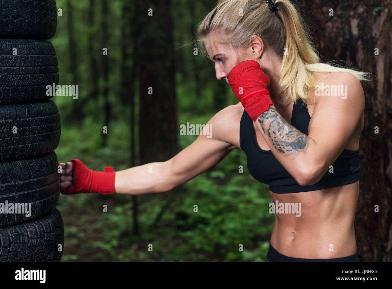 Portrait einer Boxerin, die im Freien einen Aufwärtskick macht Stockfoto