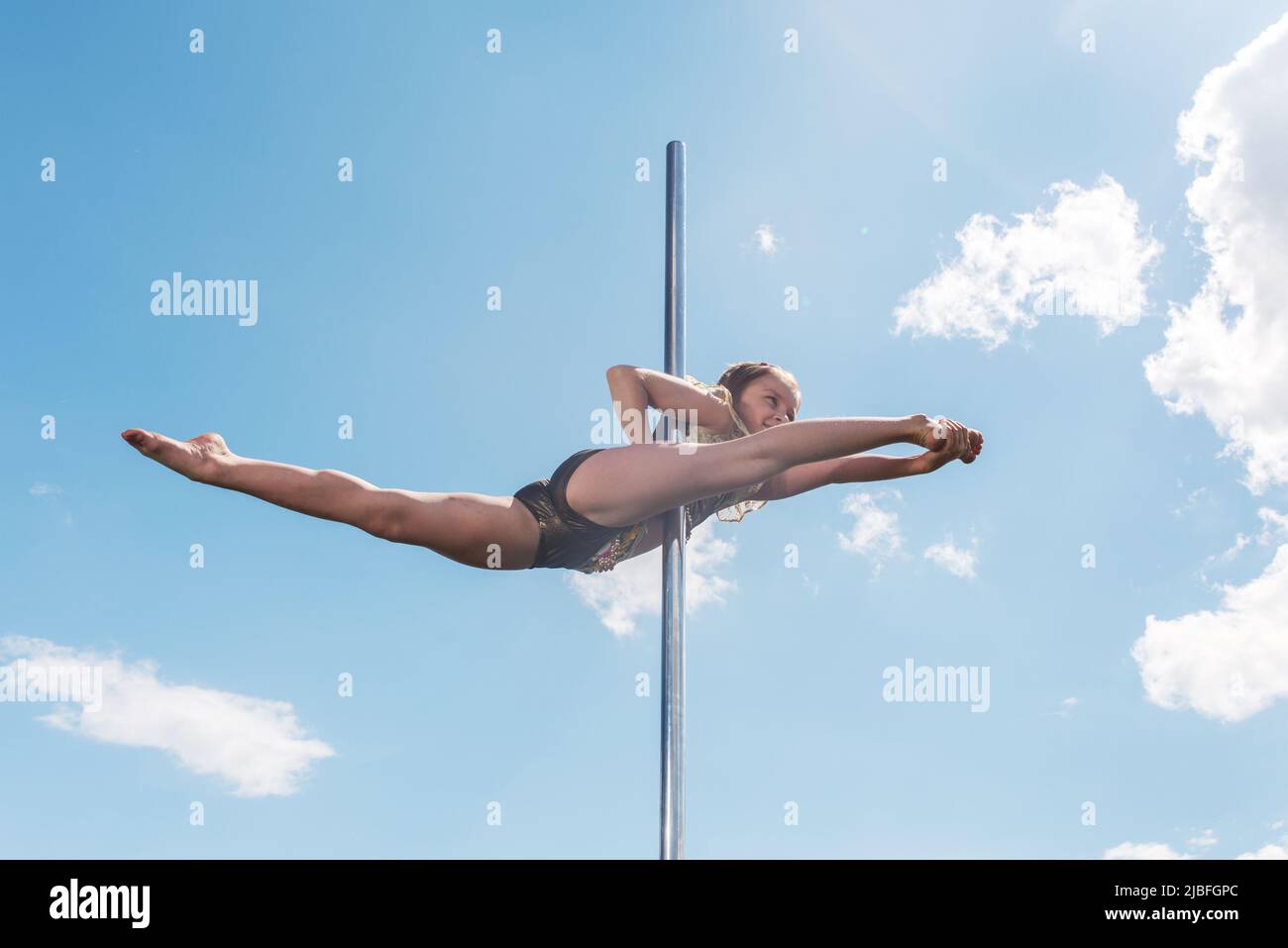 Pole dance fit Frau trainieren mit Pylon im Freien. Stockfoto