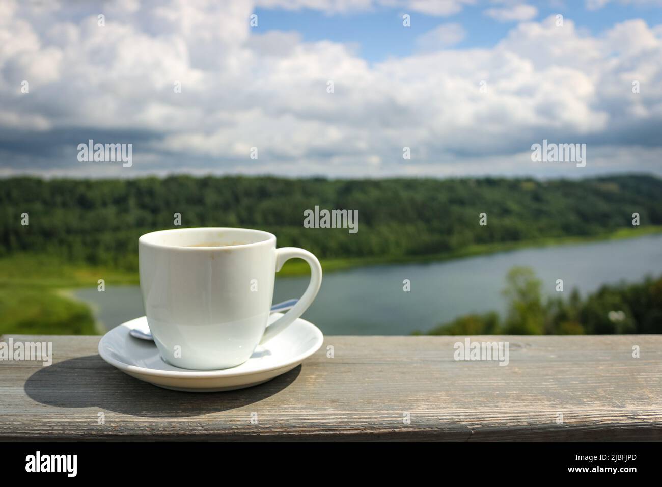 Weiße Tasse heißen Kaffee auf dem Balkon mit Natur und Berge, Hügel Hintergrund. Speicherplatz kopieren. Stockfoto