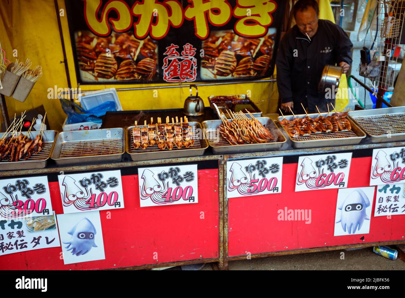 Japanischer Mann, der traditionelles Street Food auf der Insel Itsukushima verkauft Stockfoto