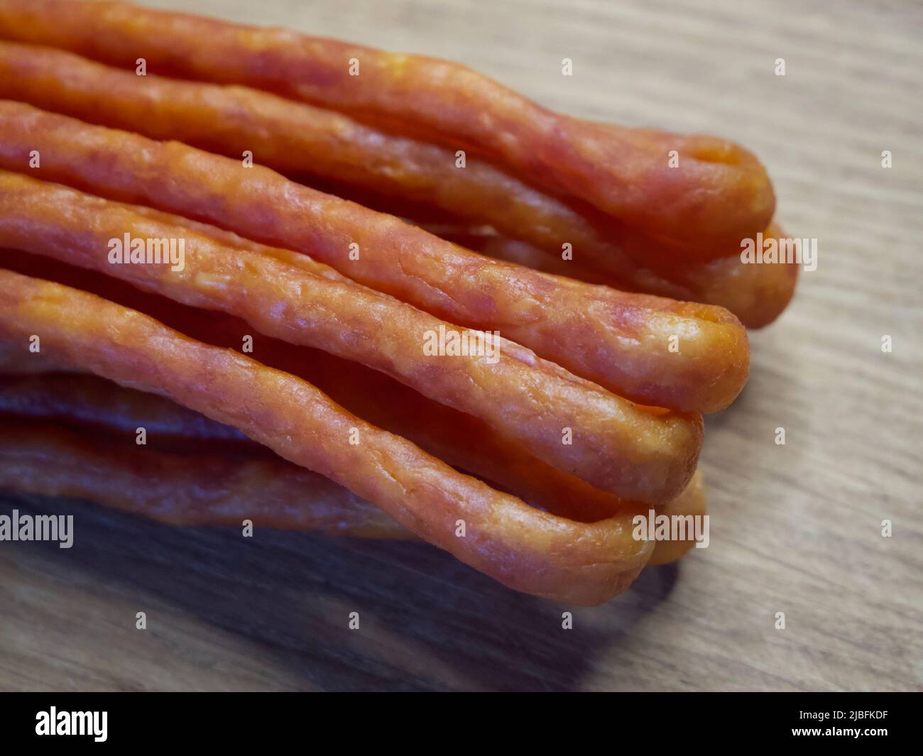 Traditionelle polnische Würste Kabanos auf einer hölzernen Oberfläche, Makrofoto. Kabanos, auch bekannt als Cabanossi oder Kabana, ist in der Regel eine lange, dünne, trockene Wurst Stockfoto