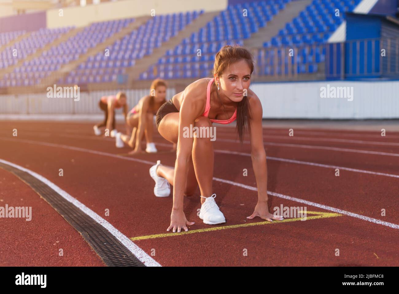 Junge Athletin an der Startposition bereit, ein Rennen zu starten Stockfoto