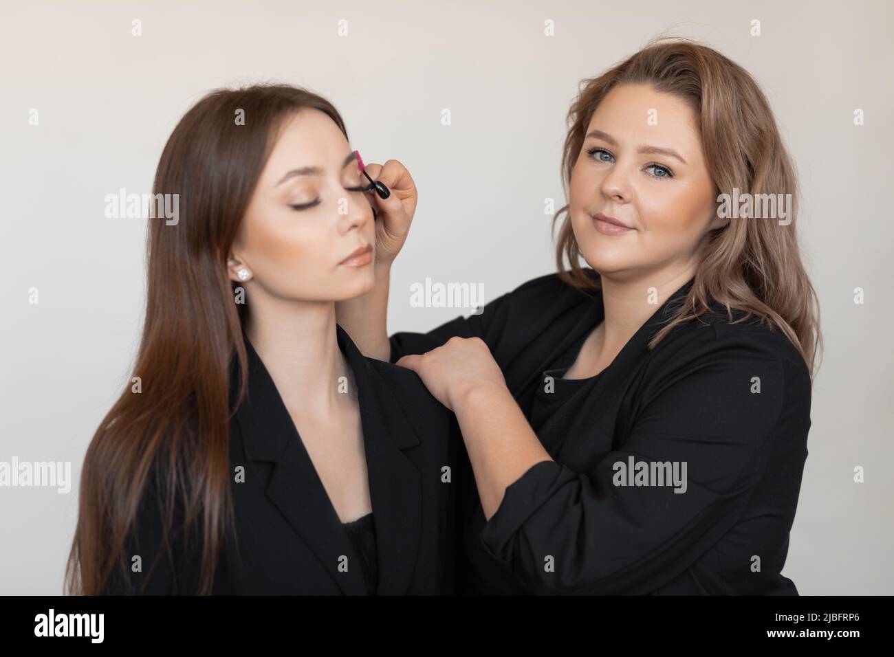 Frau Gesicht mit engen Augen in Schönheitssalon Pflege, Korrektur Augenbrauen und Wimpern durch professionelle Visagiste, Spa Stockfoto