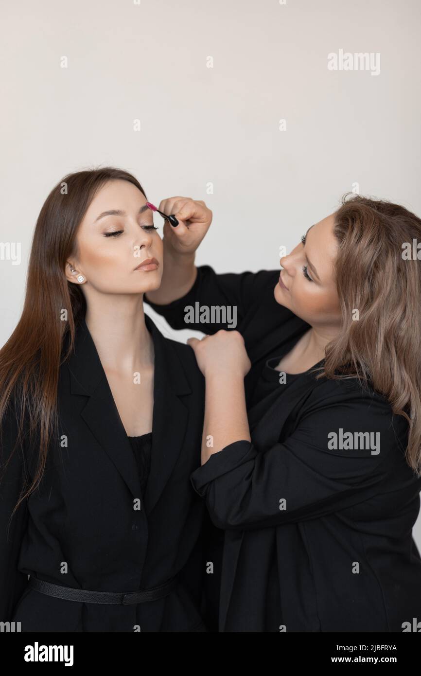 Vertikale Frau Gesicht mit engen Augen im Schönheitssalon Pflege Augenbrauen und Wimpern durch professionelle Visagiste, Spa-Pflege Stockfoto