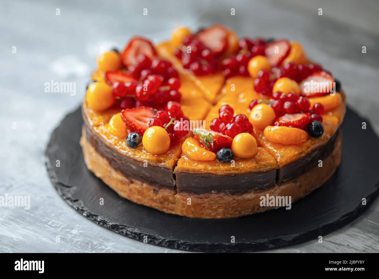 Dekorierte süße Orangenbeere und Obstkuchen Stockfoto