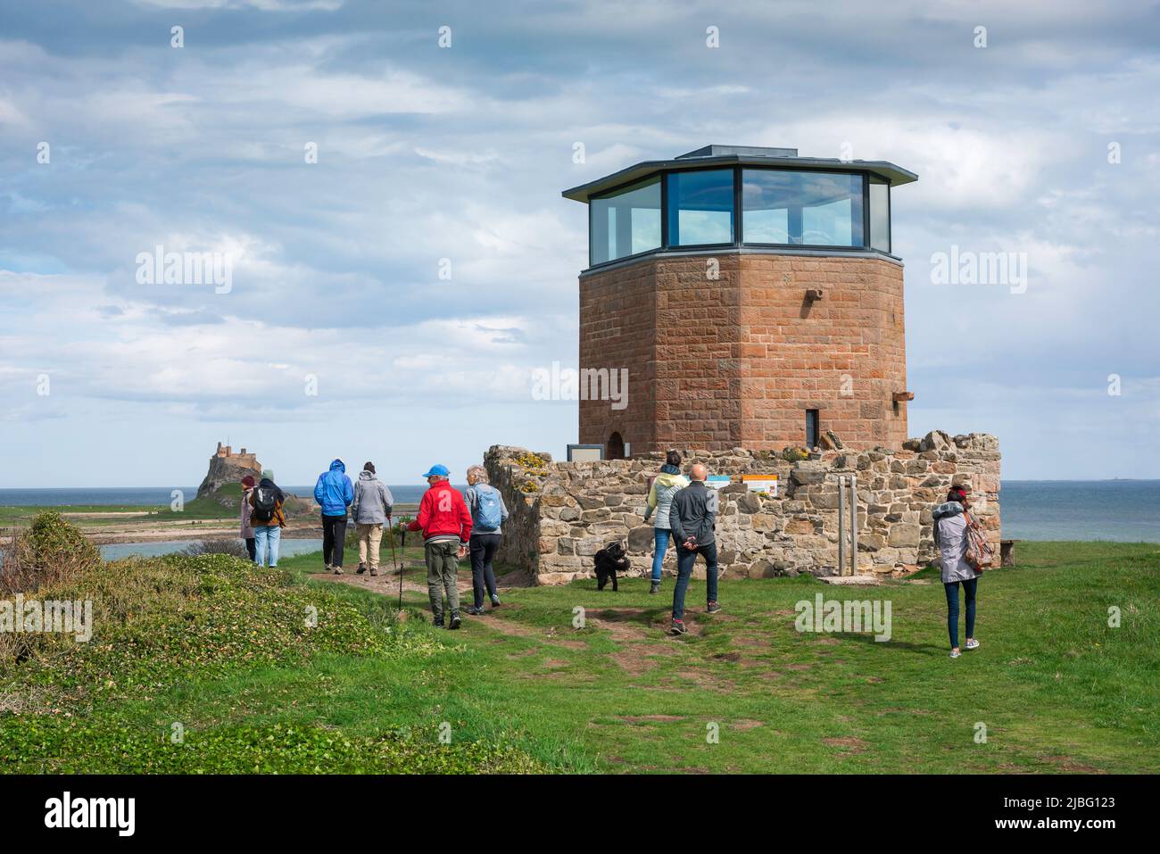 Northumberland Tourismus, Blick auf Besucher von Holy Island, die am Aussichtsturm auf Heugh Hill mit Blick auf den Hafen von Lindisfarne, England, vorbeigehen Stockfoto
