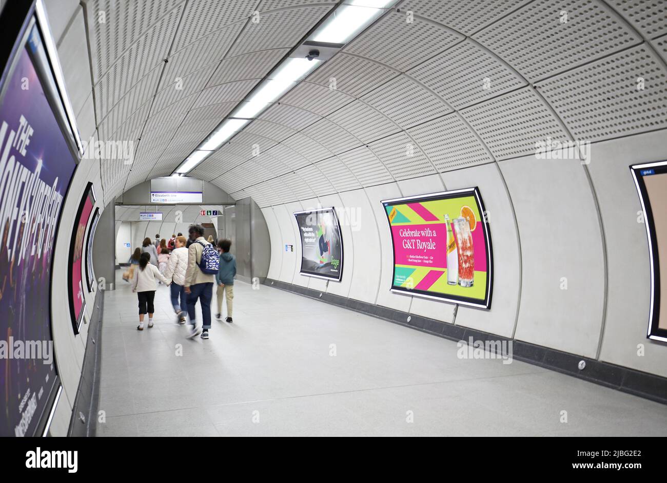 London, Großbritannien. Unterirdische Zugangstunnel am Bahnhof Liverpool Street auf dem neuen Elizabeth Line (Crossrail)-Netz. Zeigt die vorbeifahrende Familiengruppe. Stockfoto