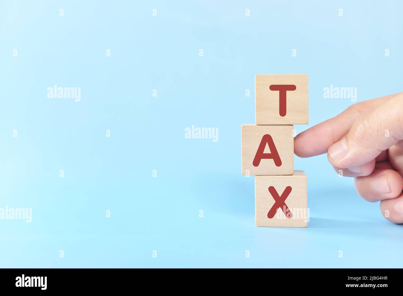 Steuerreform und Steuersenkungskonzept. Hand zerstört ein Wort Steuern in Holzblöcken. Stockfoto