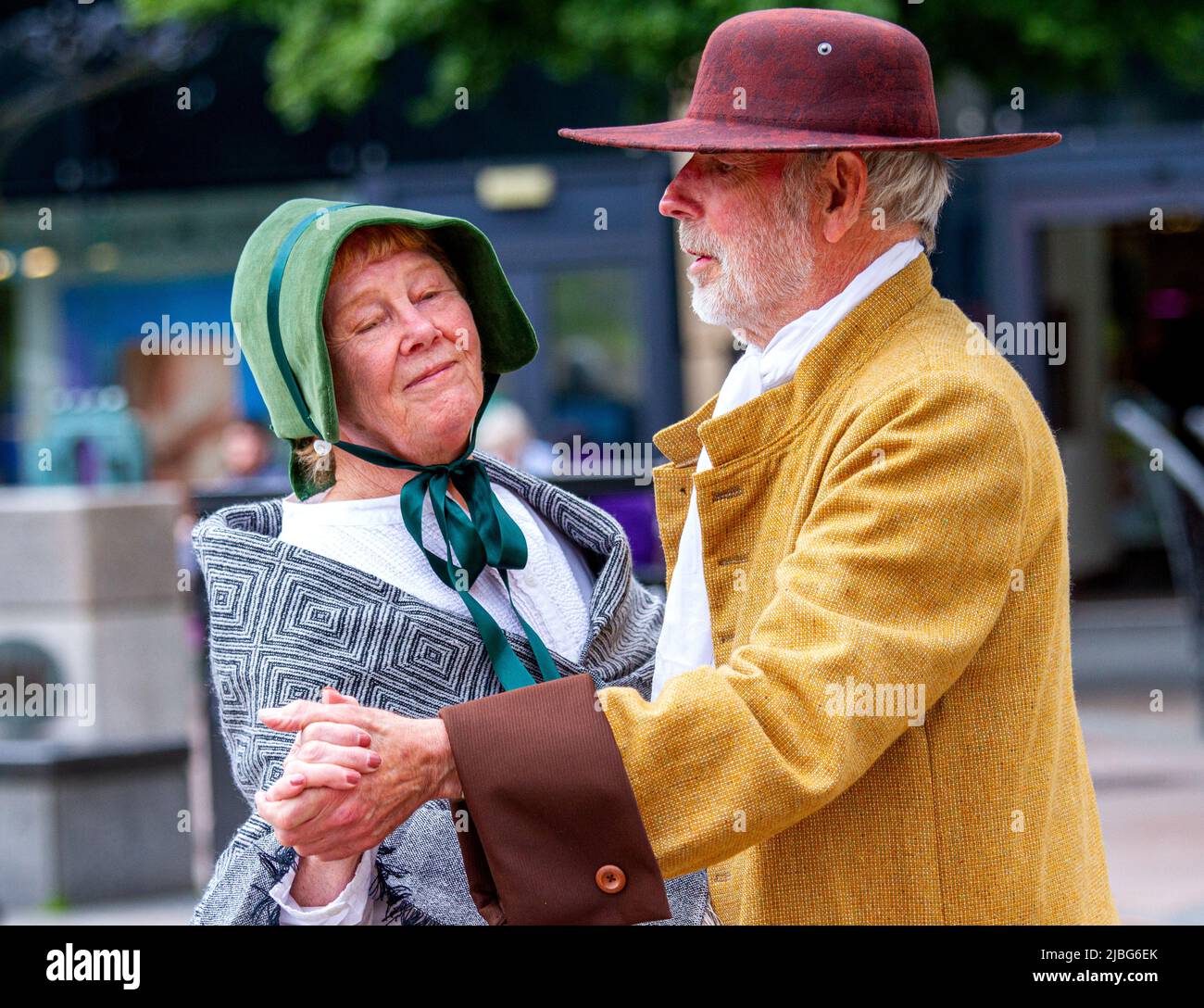 Dundee, Tayside, Schottland, Großbritannien. 6.. Juni 2022. UK Wetter: Ein warmer und sonniger Junitag mit einer kühlen leichten Brise und Höhen von 16 Grad An einem warmen Tag im Stadtzentrum von Dundee sind Pamela und Norman Alm aus Amerika in nordamerikanische Quäker-Kostüme aus dem 17.. Jahrhundert gekleidet, genießen Sie einen Tag lang Tanz zu Livemusik, gespielt von einem lokalen Glam Rock Musiker. Kredit: Dundee Photographics/Alamy Live Nachrichten Stockfoto