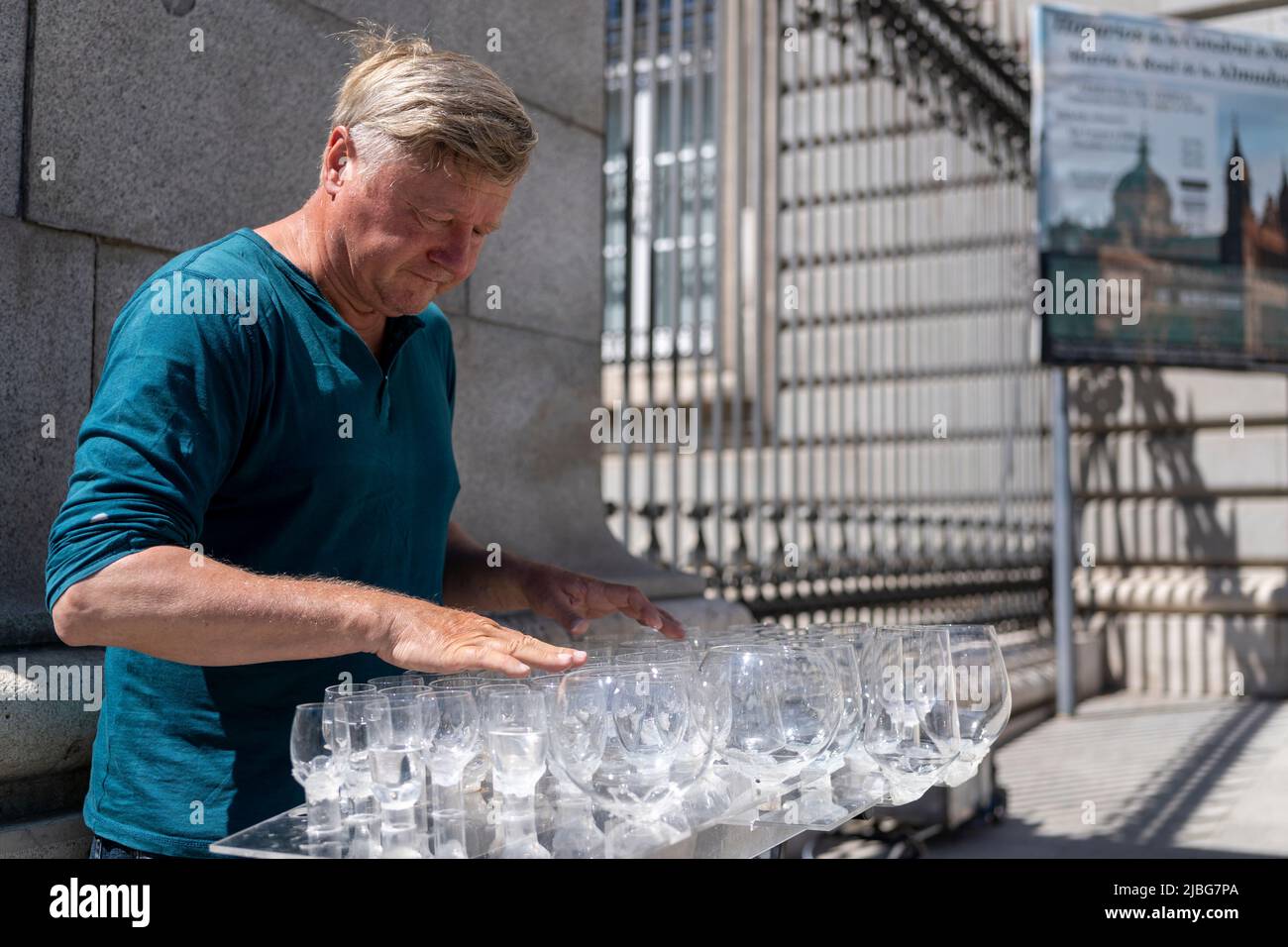 Straßenmusiker, der vor der Kathedrale von Madrid in Spanien Wassergläser spielt Stockfoto