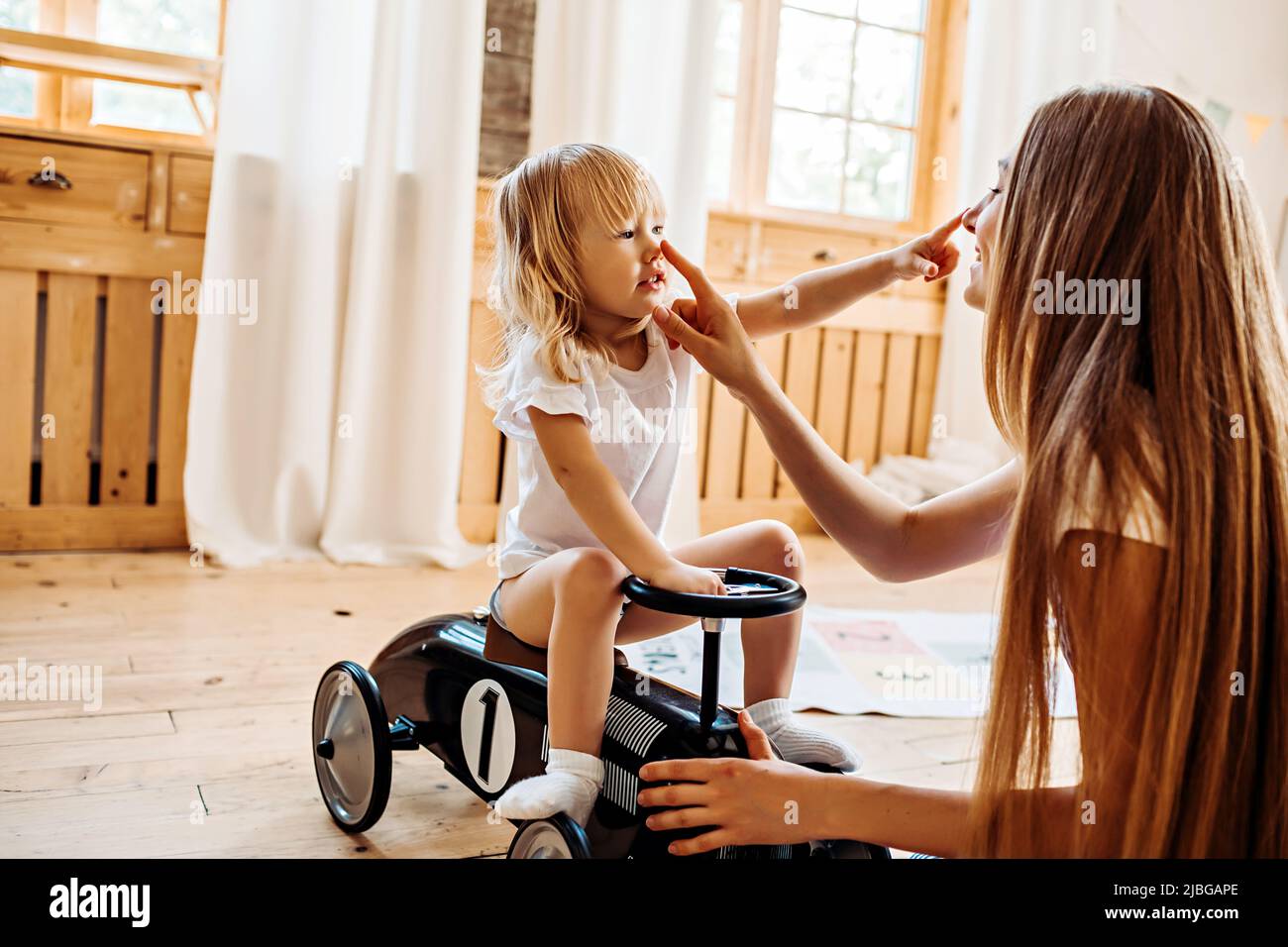 Junge Mutter oder Babysitter spielen mit kleinen Kind zu Hause Stockfoto