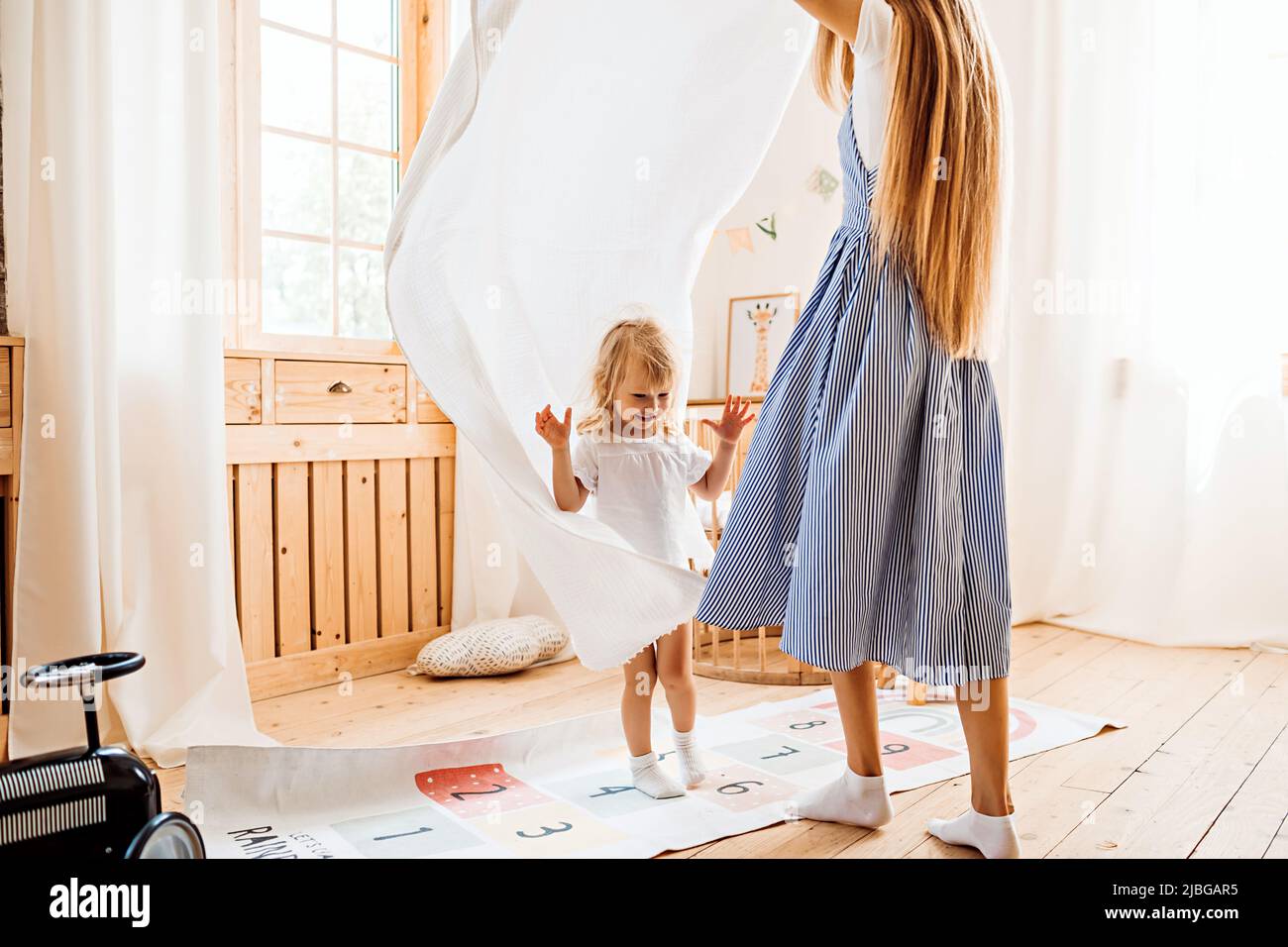 Junge Mutter oder Babysitter spielen mit kleinen Kind zu Hause Stockfoto