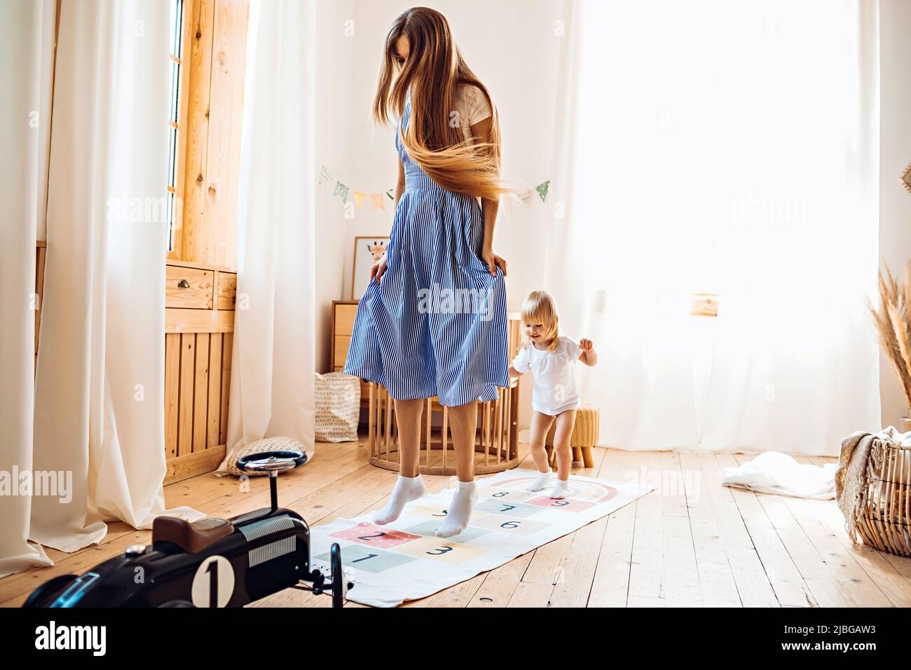 Junge Mutter oder Babysitter spielen mit kleinen Mädchen zu Hause Stockfoto