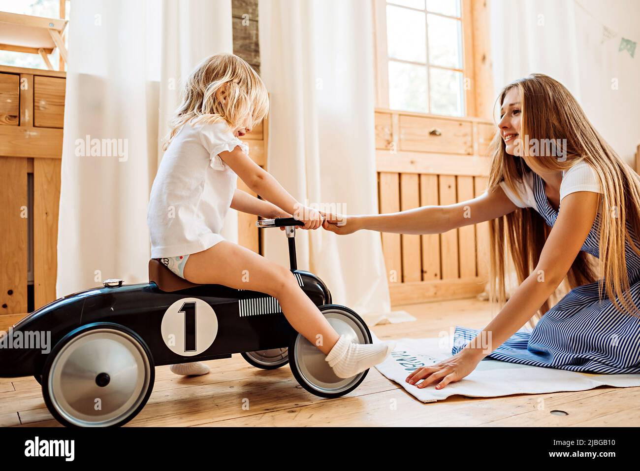 Junge Mutter und kleine Tochter haben Spaß und lachen im Schlafzimmer zu Hause. Familienbild Stockfoto