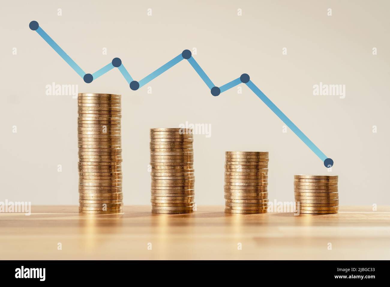 Nahaufnahme Foto von ständig abnehmenden Münzen mit Pfeil auf isoliertem Hintergrund. Konzept des Verlusts von Geld und Bankrott oder Scheitern eines neuen Start-ups. Stockfoto
