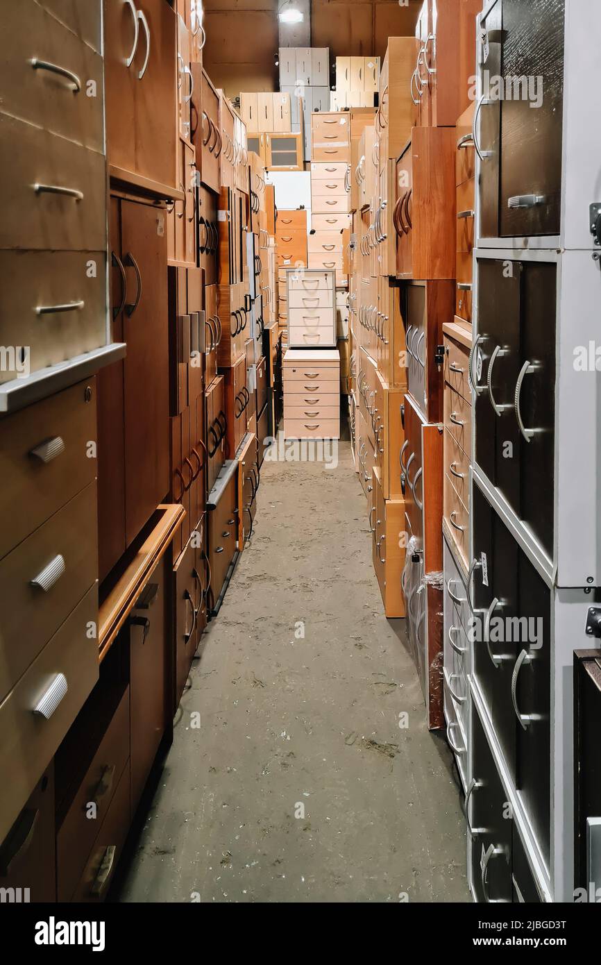 Lager von Büromöbeln. Ungewöhnlicher Korridor mit Nachttischen. Verkauf von gebrauchten Schränken. Möbelgeschäft. Stockfoto