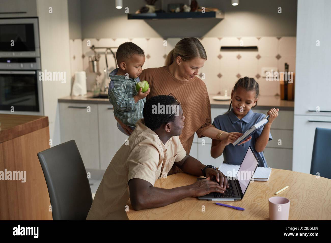 Porträt der multiethnischen Familie mit zwei Kindern in häuslichen Interieur schwarz und kaukasischen Elternpaar Stockfoto