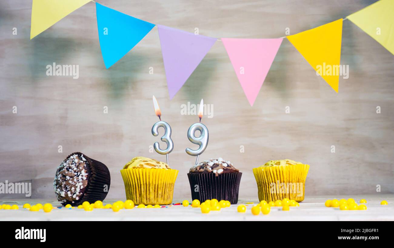 Geburtstag Hintergrund mit Nummer. Wunderschöne Geburtstagskarte mit bunten Girlanden, einem Muffin mit einem Kerzenbrenner-Copyspace. Stockfoto