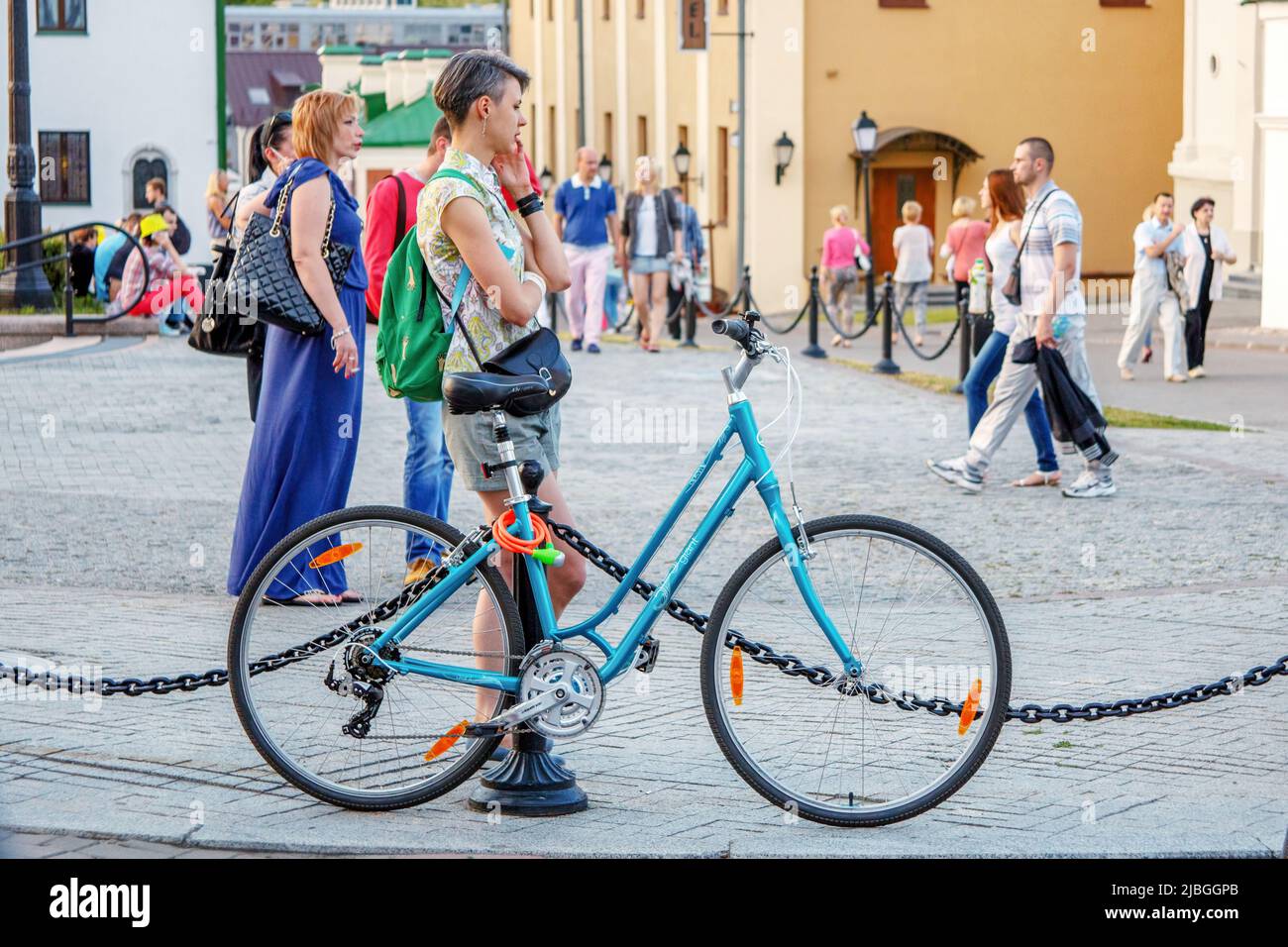 Minsk, Weißrussland - 18. Juli 2015: Ein hübsches Mädchen mit Fahrrad telefoniert. Tägliches Leben in der Abendstadt im Sommer Stockfoto