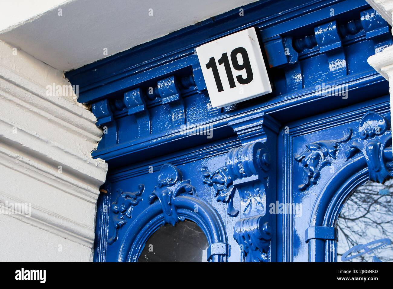 Alte Wohnungstür mit blauer Farbe mit Nummer 119, Ost-Berlin, Deutschland. Stockfoto