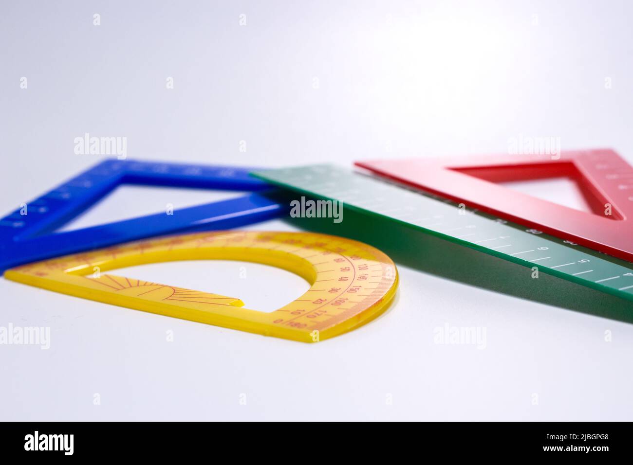 Konzeptbild von bunten Linealen und Winkelmesser in weißem Hintergrund. Stockfoto