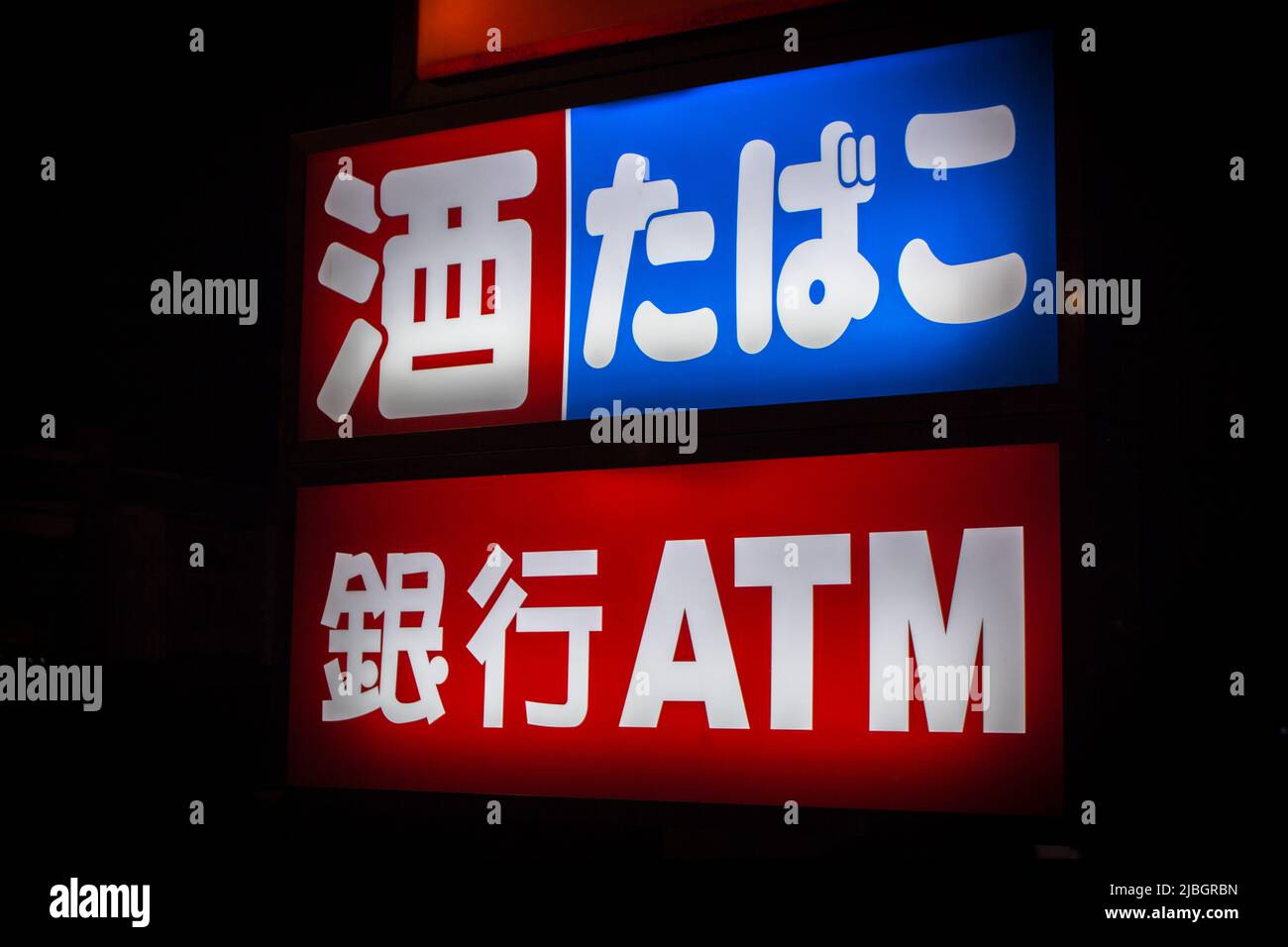 Werbung Zeichen in Japanisch von 24-Stunden-Geschäft in der Nacht. Übersetzung: Alkohol, Zigarette und Geldautomat. Stockfoto