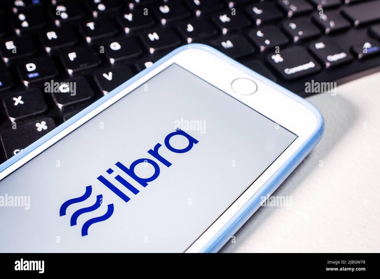 Kumamoto, Japan - Nov 26 2019 : das Logo von Libra, einer digitalen Blockchain-Währung von Facebook, Inc., auf einem iPhone-Bildschirm mit Tastatur auf weißem Tisch. Stockfoto
