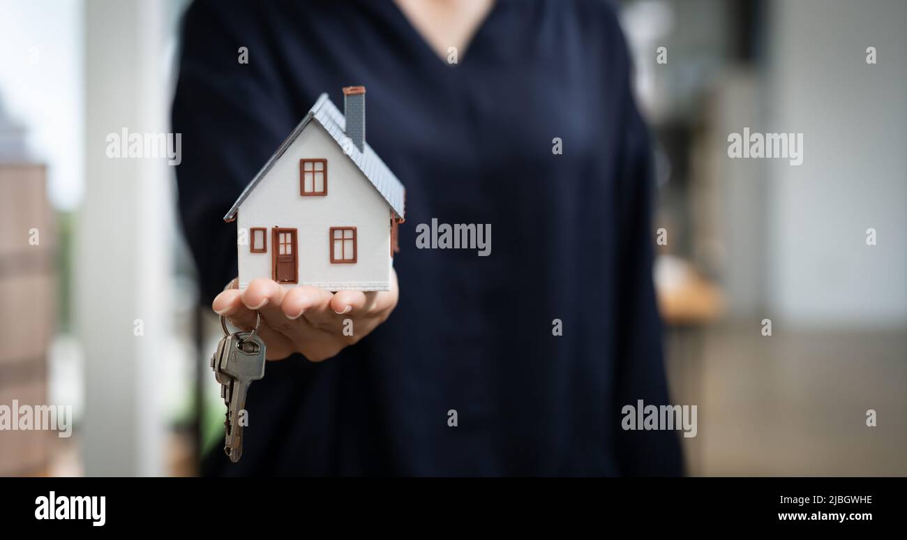 Immobilienmakler, der Schlüsselhaus und Modell übergibt, das Versicherungskonzept vermietet und verkauft. Stockfoto