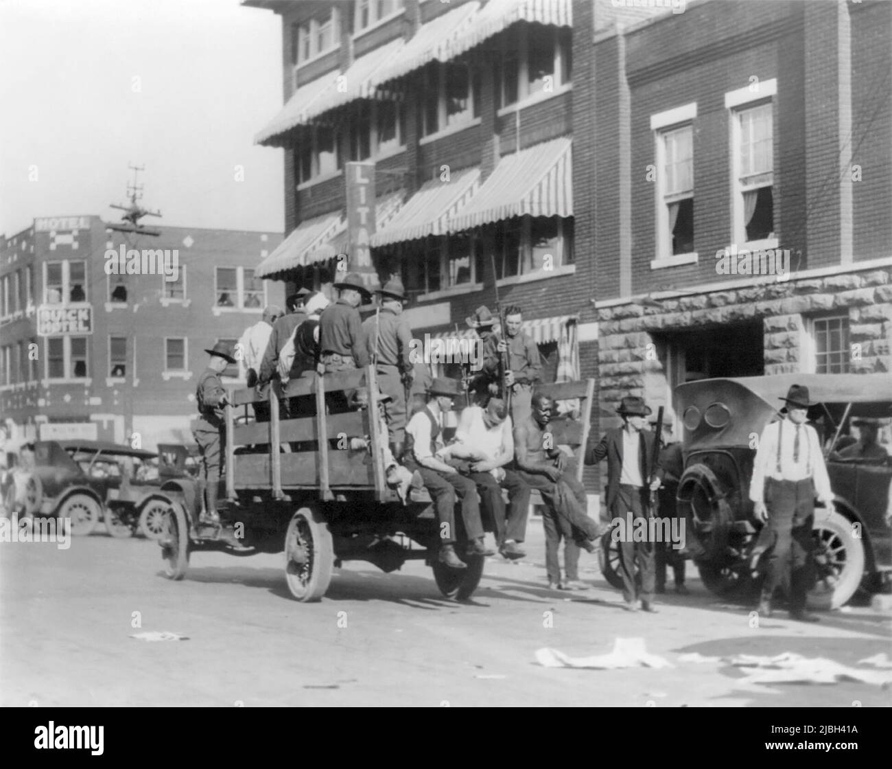 Afro-Amerikaner und weiße Soldaten und Zivilisten auf und neben einem Lastwagen während des Tulsa Race Massakers, auch Tulsa Race Riot genannt, als ein weißer Mob 1921 das überwiegend afroamerikanische Greenwood-Viertel von Tulsa, Oklahoma, Angriff. (USA) Stockfoto