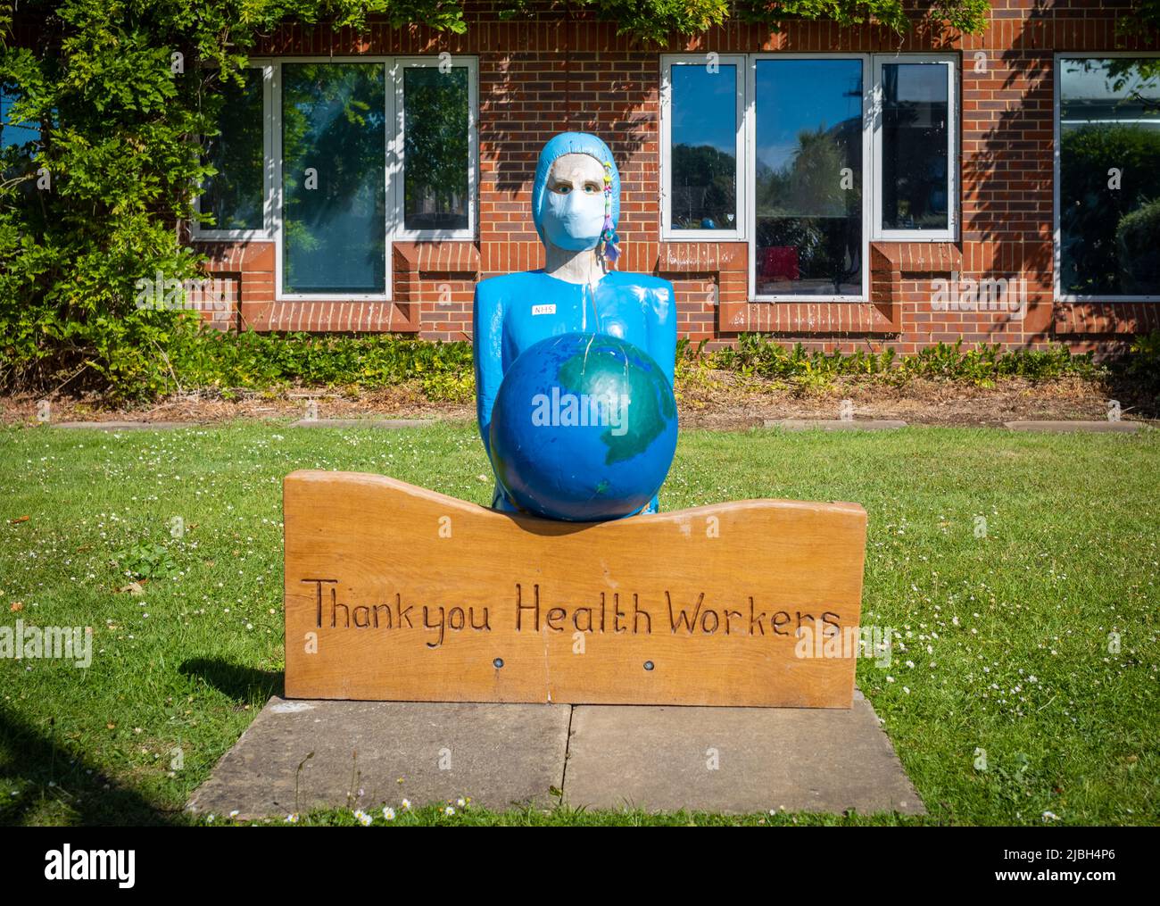Eine Gedenkstätte für eine Krankenschwester, die eine Gesichtsmask trägt und einen Globus hält, um Gesundheitshelfern für ihre Arbeit während der COVID-19-Pandemie zu danken. Stockfoto