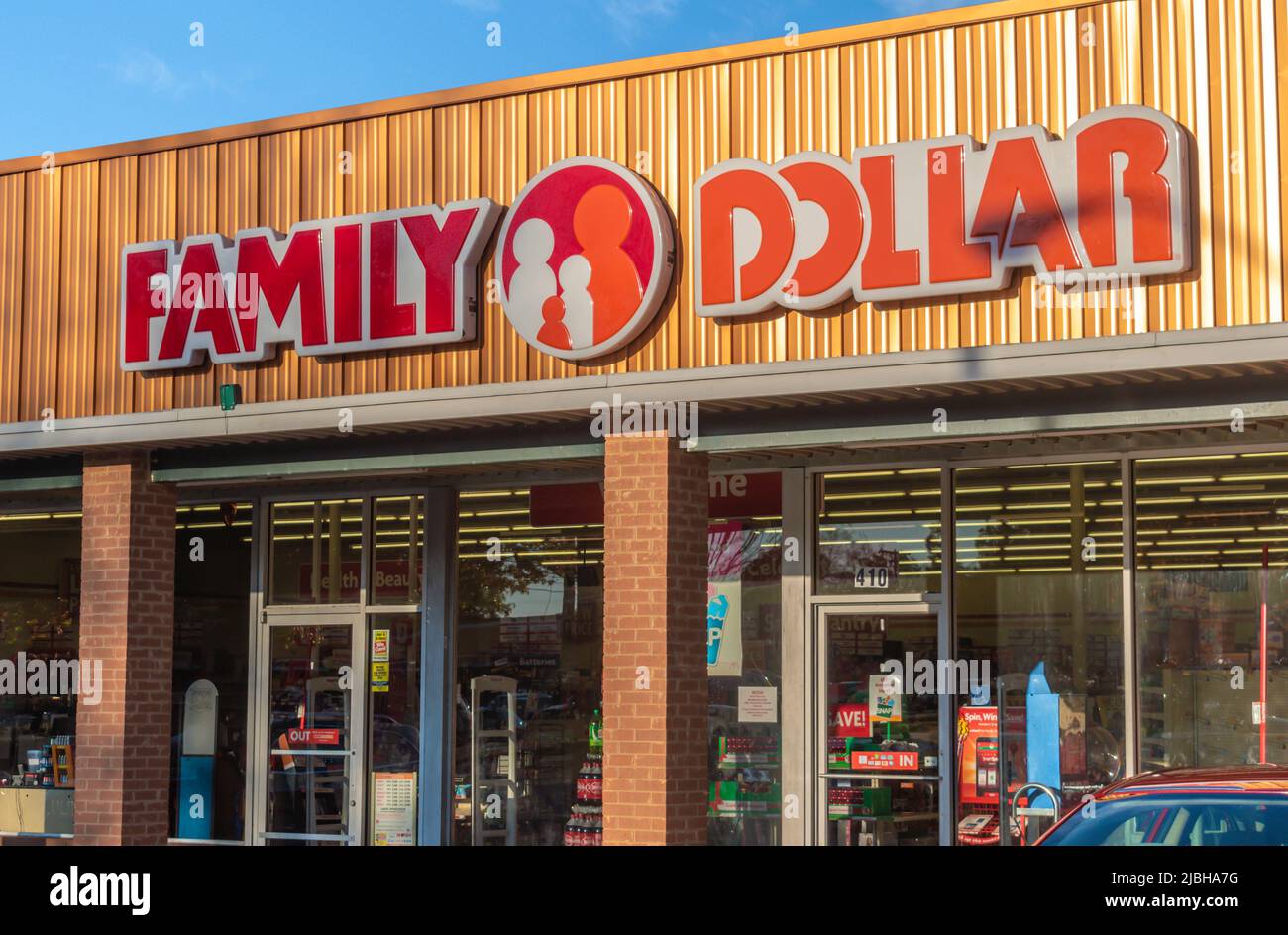 Family Dollar Außenfassade mit Marken- und Logo-Schildern in rot, weiß und orange über der Glasfassade im sanften Licht des Sonnenuntergangs in einem Einkaufszentrum. Stockfoto