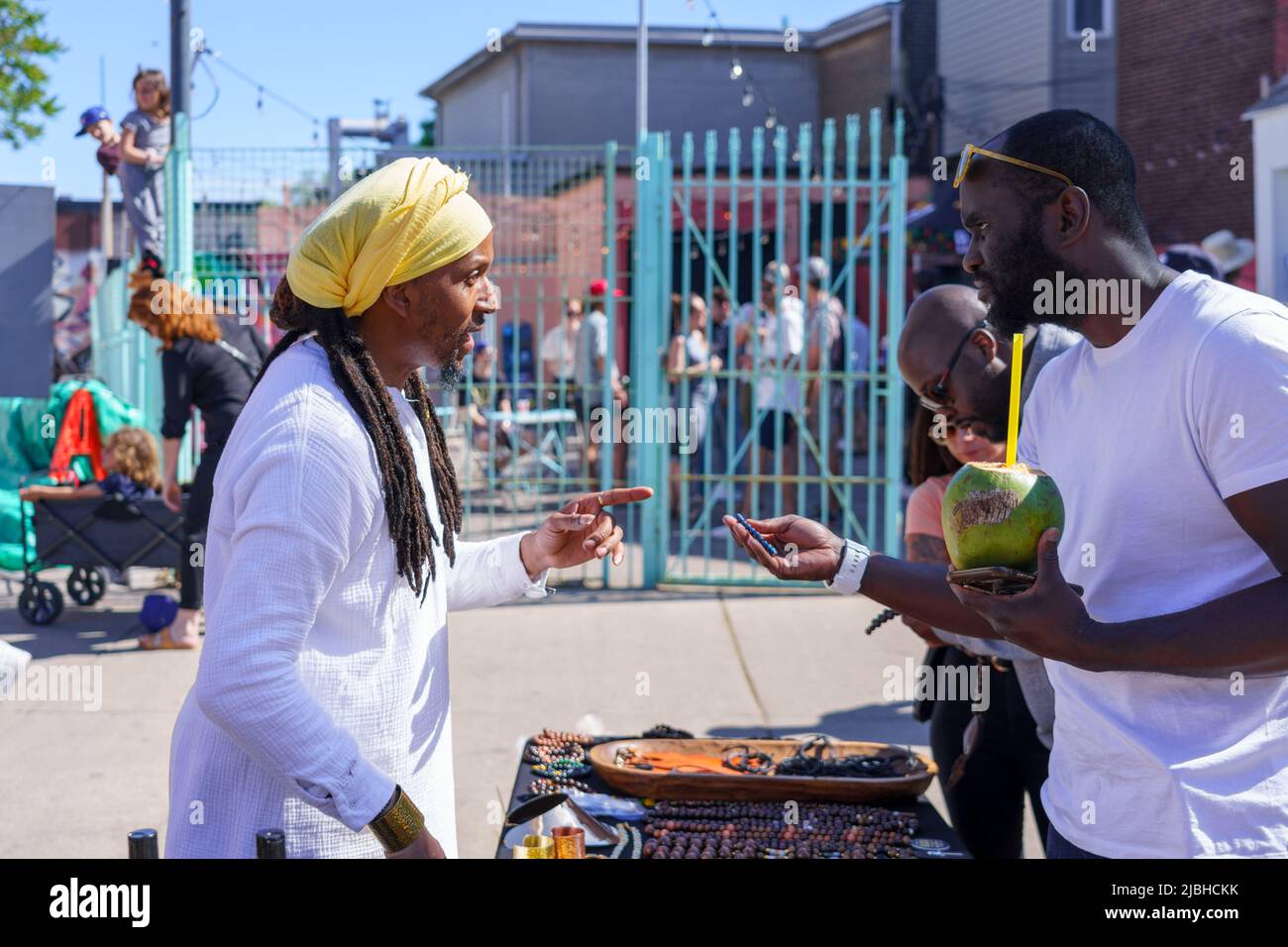 Ein Mann afro-karibischer Abstammung verkauft während des Do West Festivals in einem Kiosk Souvenirs. Stockfoto