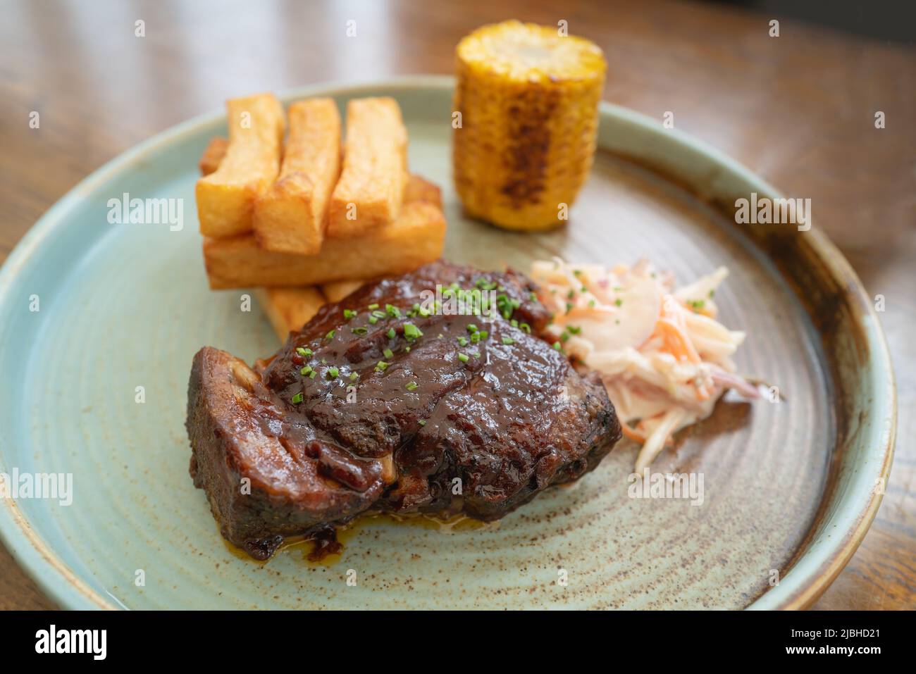 Zartes Steakfleischgericht mit klobigen Pommes Frites, Krautsalat und Maiskolben. Stockfoto