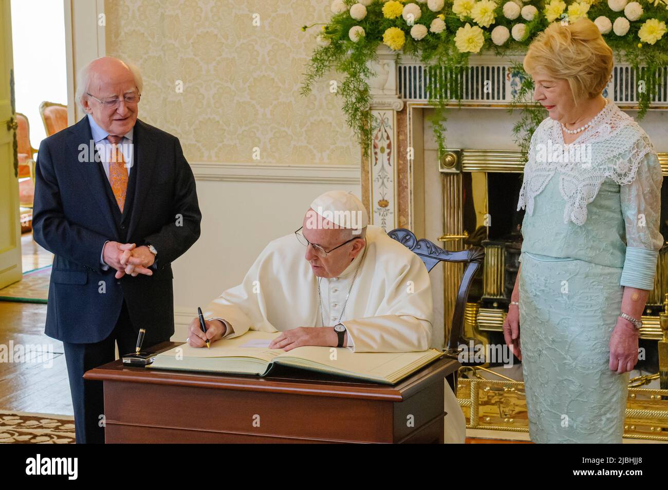 Dublin, Irland. 26/08/2018 - Papst Franziskus signiert das Besucherbuch, während Michael D Higgins und Sabina Higgins im Aras an Uachtarain, Dublin, Republik Irland, auf das Buch blicken Stockfoto