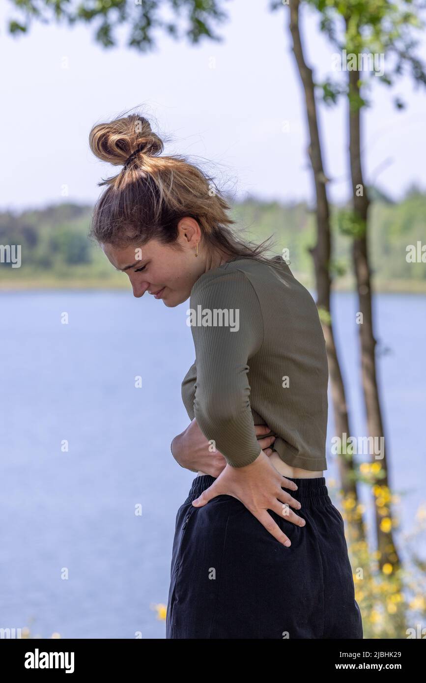 Menschen, Gesundheit und Problemkonzept - Frau leidet an Rückenschmerzen oder Zügel im Freien. Hochwertige Fotos Stockfoto