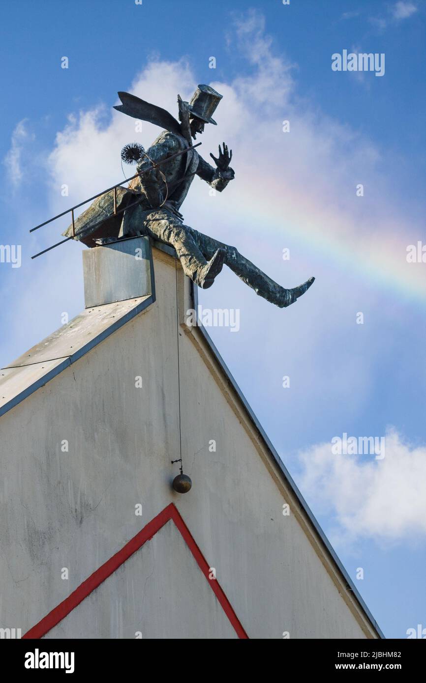 Denkmal für den Schornsteinfeger in Klaipeda, Litauen. Blauer Himmel mit weißen Wolken und Regenbogen. Vertikales Foto. Stockfoto