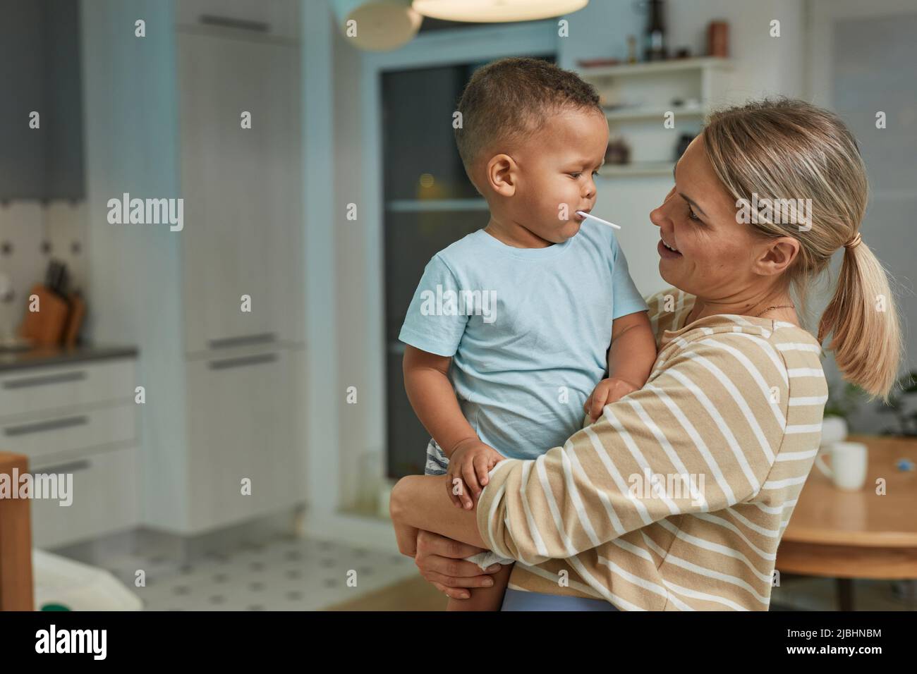 Porträt von glücklichen kaukasischen Mutter hält niedlichen Kleinkind Jungen in der Küche zu Hause Innenraum, kopieren Raum Stockfoto
