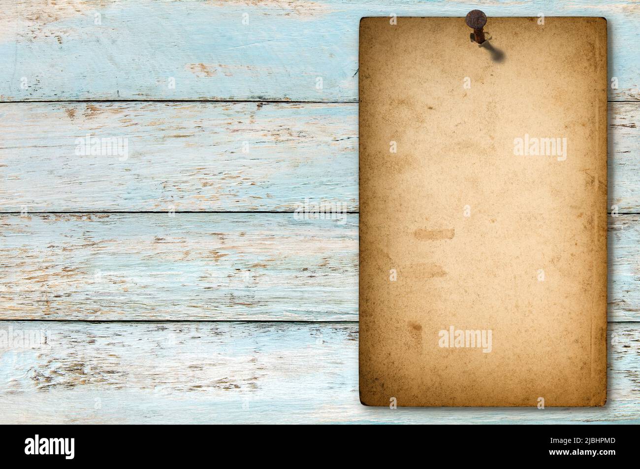 Altes Papierposter mit verrosteten Nagel auf Holzhintergrund angebracht Stockfoto