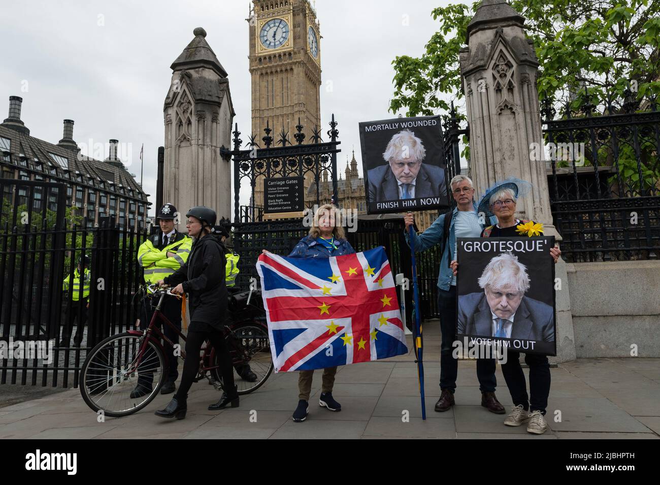 London, Großbritannien. 06.. Juni 2022. Demonstranten halten Plakate und eine Flagge vor dem Parlamentsgebäude, während Abgeordnete der Konservativen Partei in einer Vertrauensabstimmung gegen Premierminister Boris Johnson ihre Stimme abgeben. Das Vertrauensvotum wurde ausgelöst, nachdem mindestens 54 Abgeordnete ihre Misstrauensbriefe an Sir Graham Brady, den Vorsitzenden des konservativen Ausschusses 1922 für die Hinterbank, eingereicht hatten, nachdem Sue Grays Bericht in Covid-Sperrparteien in der Downing Street veröffentlicht worden war. Quelle: Wiktor Szymanowicz/Alamy Live News Stockfoto