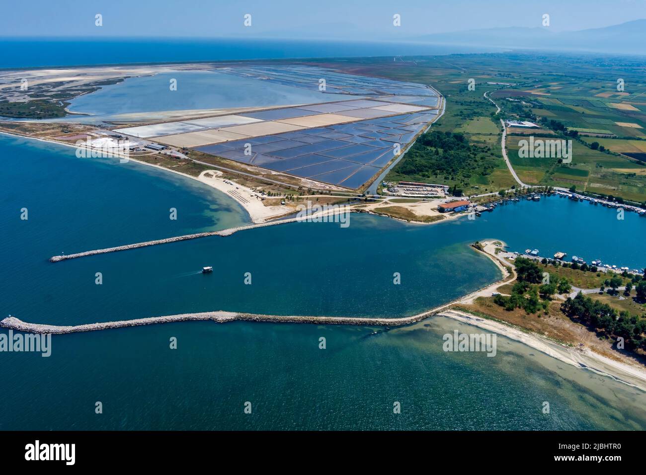 Luftaufnahme des Hafens und des Strandes von Kitros Pieria und im Hintergrund Salzverdunstungsteiche und Salzhügel. Griechenland Stockfoto