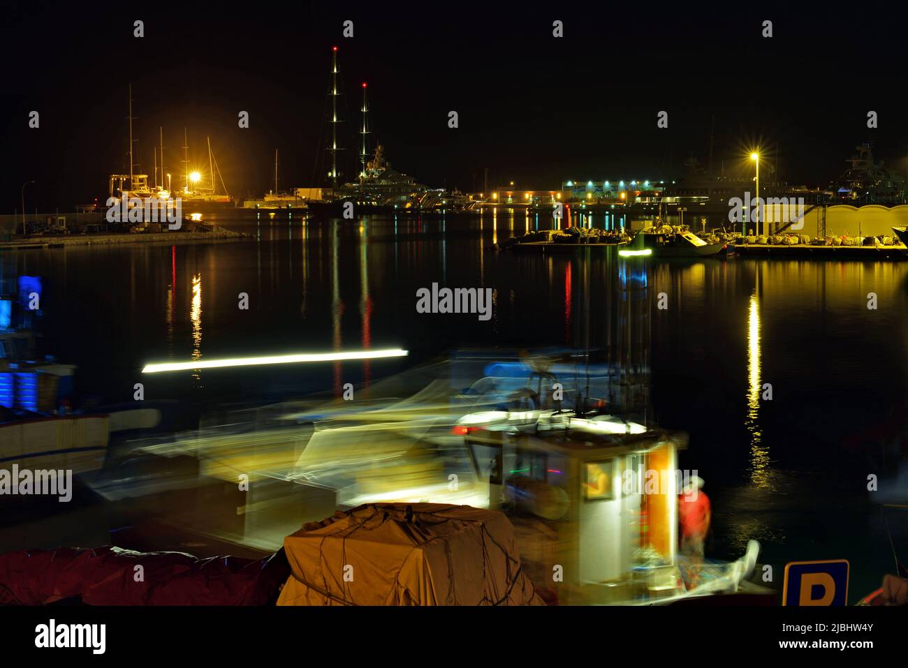 Fischerboot manövriert nachts im Hafen Stockfoto