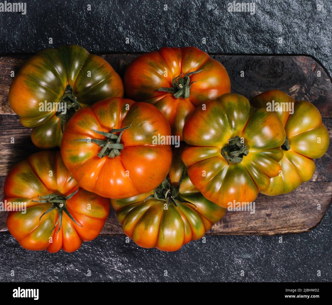 Eine Gruppe von Costoluto großen Tomaten auf einem grauen Holzhintergrund Stockfoto