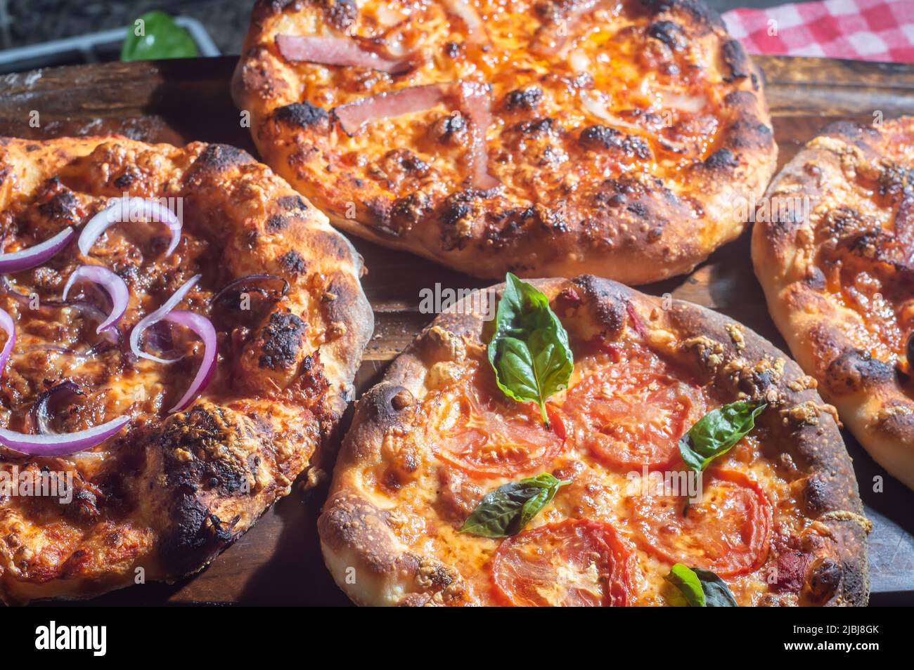 Hausgemachte italienische Pizza mit natürlicher Gärung, verschiedene Geschmacksrichtungen, darunter Pastrami, Speck und Pulled Pork, Pizza-Konzept. Stockfoto