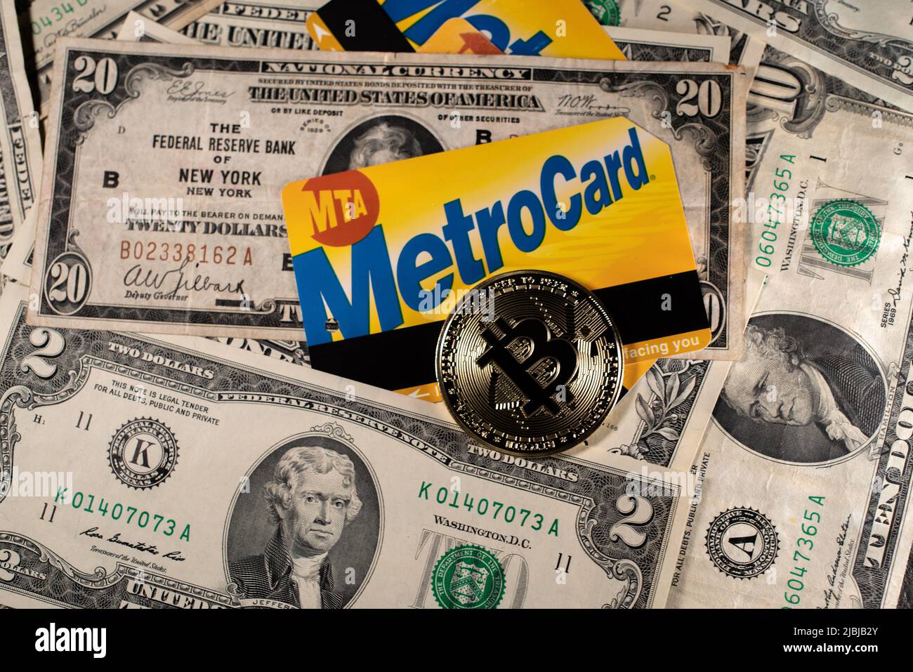 Manhattan, New York/USA - März 26. 2021: Bitcoin auf NYC Metro-Karte und Dollar-Banknoten. Kauf eines Fahrscheins für den öffentlichen Nahverkehr mit Kryptowährung oder USA Stockfoto