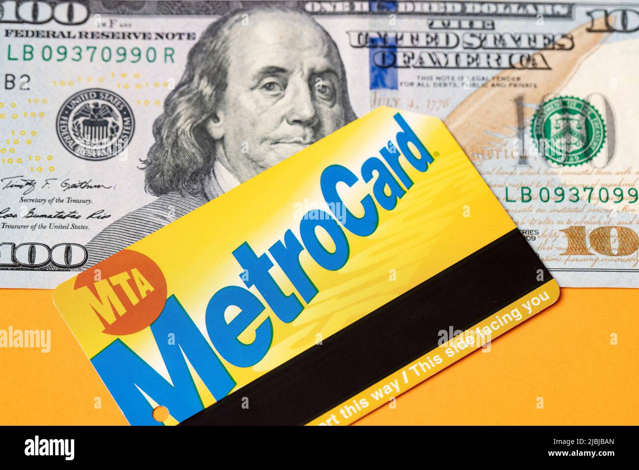 Manhattan, New York/USA - April 8. 2021: MetroCard auf hundert Dollar-Banknoten. US-Papiergeld mit Fahrschein für öffentliche Verkehrsmittel Stockfoto