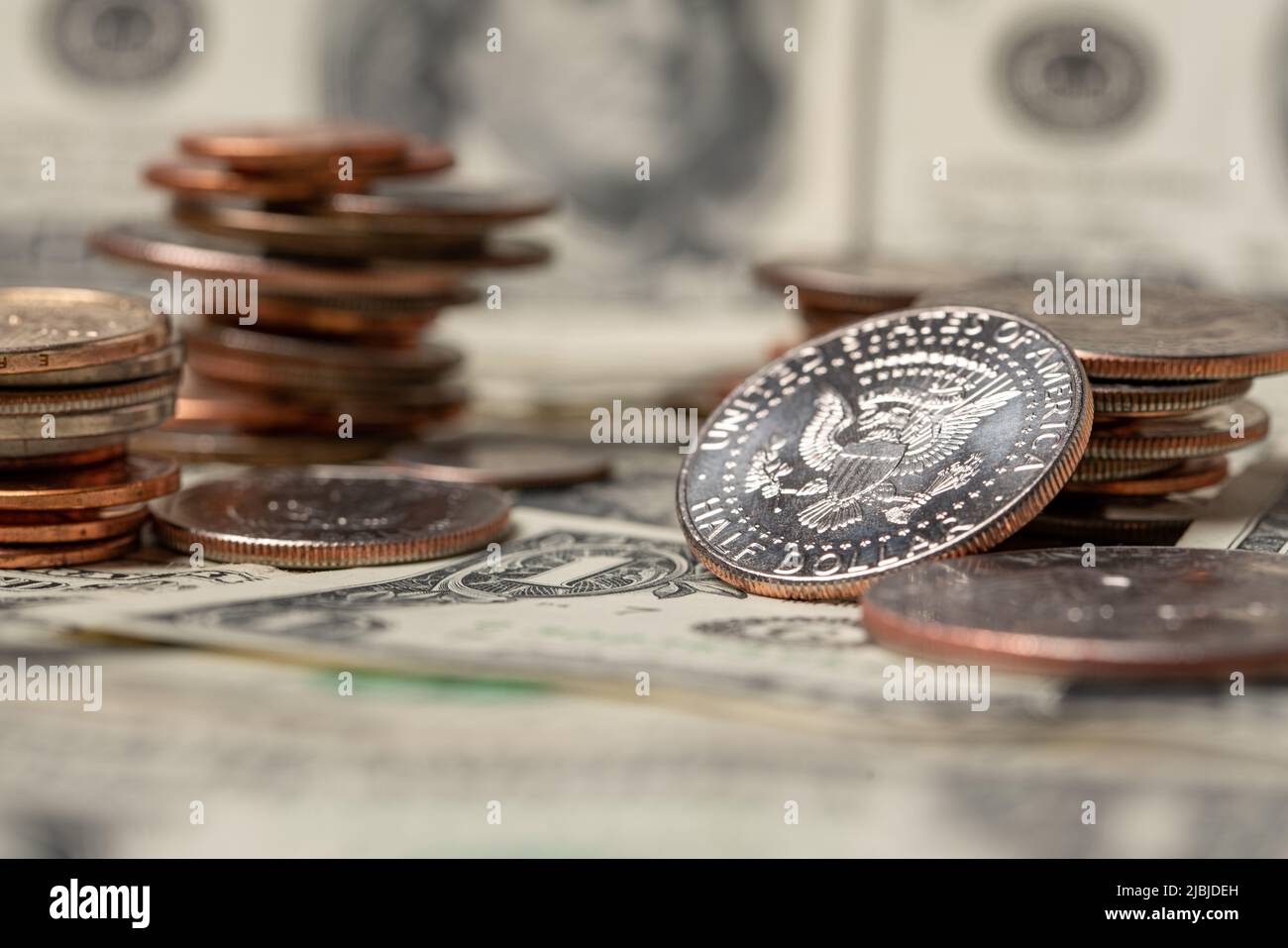 Aufgestapelt Dollar-Münzen, halbe Dollar-Münze mit Banknoten im Hintergrund. US-Dollar-Währung. Bargeld Geld und Wirtschaft in den Vereinigten Staaten, Konzept Stockfoto