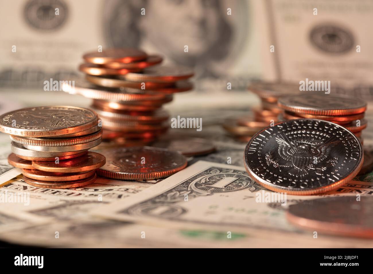Angehäuft Dollar-Münzen, Banknoten im Hintergrund. Halber Dollar auf der rechten Seite. USD-Währung der Vereinigten Staaten von Amerika. Tipp und Gehaltsscheck Konz Stockfoto